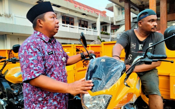 Kepala Bappelitbangda Kota Ternate, Rizal Marsaoly bersama salah satu operator sampah Kelurahan. (Dok : Foto Istimewa)
